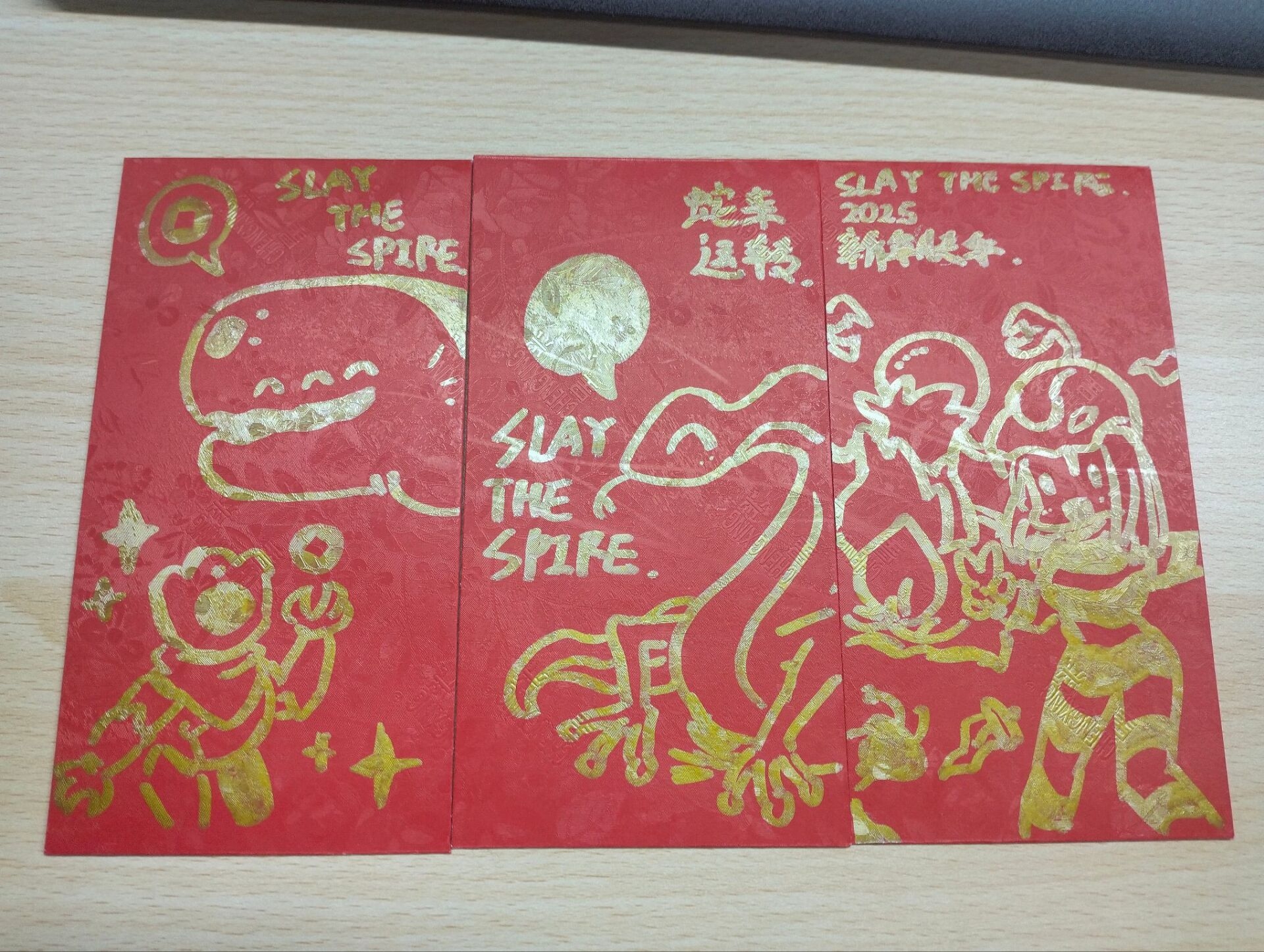 A red Lunar New Year envelope featuring golden drawings of Slay the Spire characters